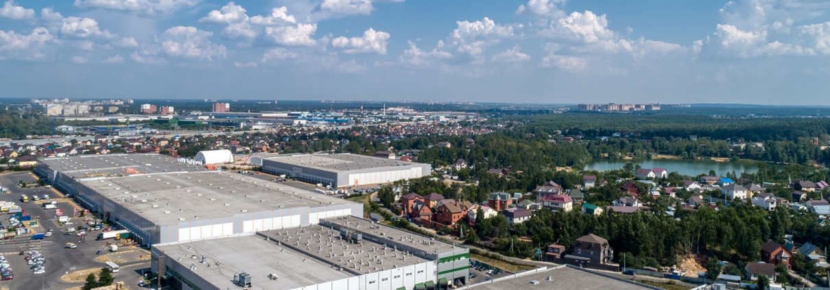A flat roof on a large commercial building with the words “Why do commercial buildings have flat roofs?” above it.