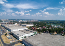 A flat roof on a large commercial building with the words “Why do commercial buildings have flat roofs?” above it.