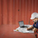 A professional roofer sitting at a computer adding information into a roof asset management portal.