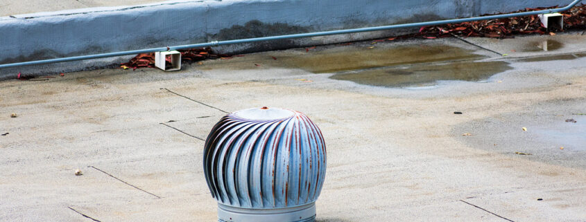 An image of a whirlybird on a commercial flat roof, one of the many roof vent types.