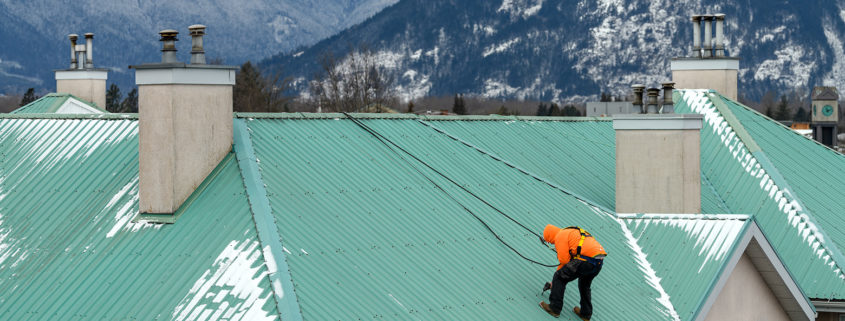 Commercial roofer performing roof maintenance program repairs.