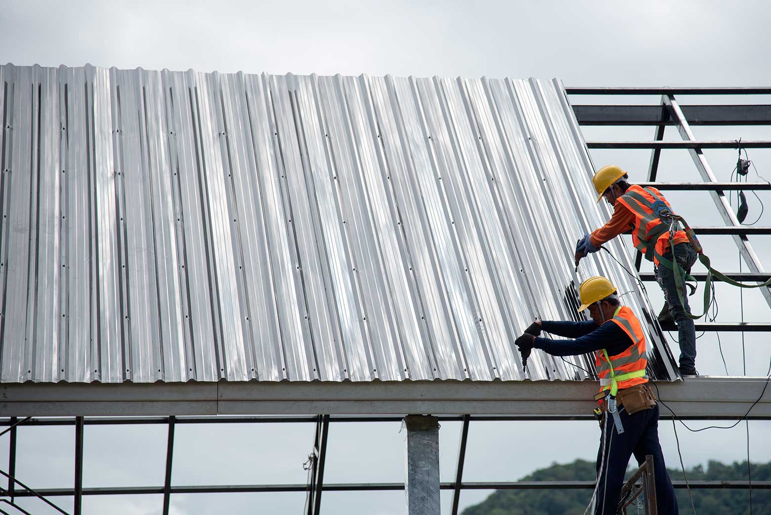 Roofing contractors installing a steel roof on a commercial building.