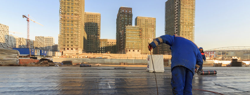 Workers performing maintenance on a built-up roof.