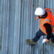 A construction worker walking on commercial roof for cooperative purchasing project.