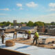 Professional roofers performing commercial roof restoration.